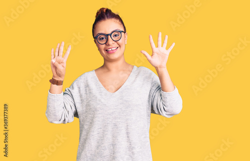 Young latin woman wearing casual clothes showing and pointing up with fingers number nine while smiling confident and happy.