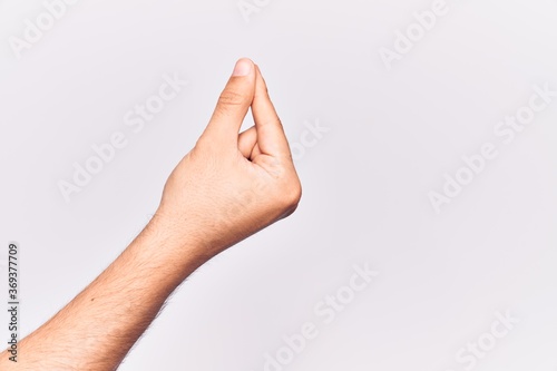 Close up of hand of young caucasian man over isolated background holding blank space with thumb finger  business and advertising