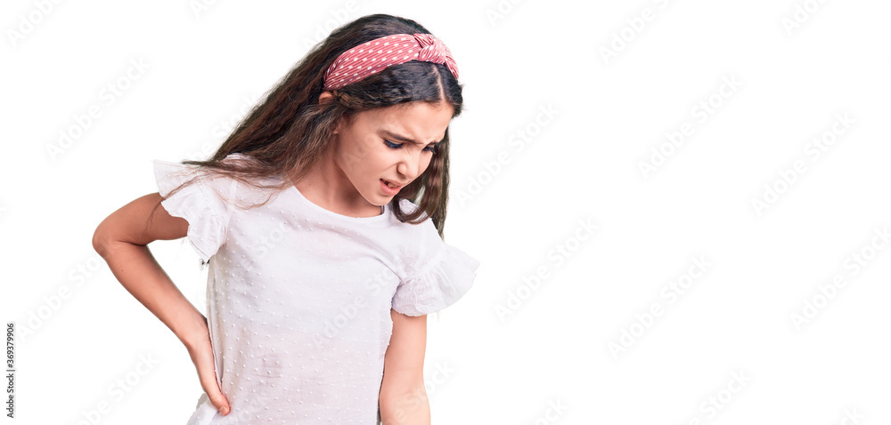 Cute hispanic child girl wearing casual white tshirt suffering of backache, touching back with hand, muscular pain