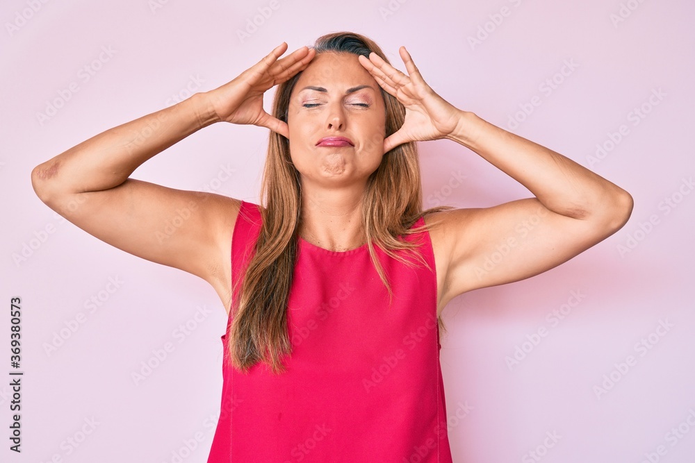 Middle age hispanic woman wearing casual clothes with hand on head, headache because stress. suffering migraine.