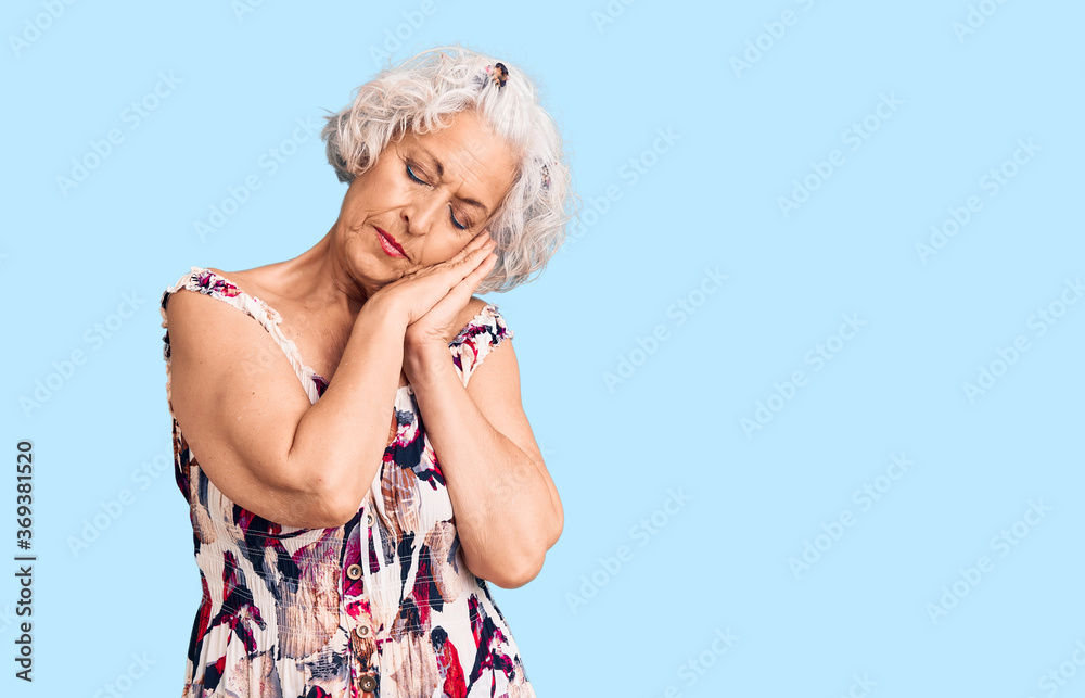 Senior grey-haired woman wearing casual clothes sleeping tired dreaming and posing with hands together while smiling with closed eyes.