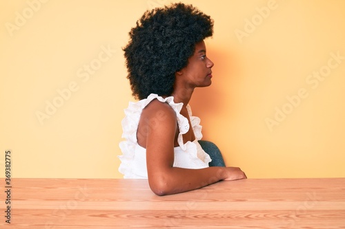 Young african american woman wearing casual clothes looking to side, relax profile pose with natural face with confident smile.