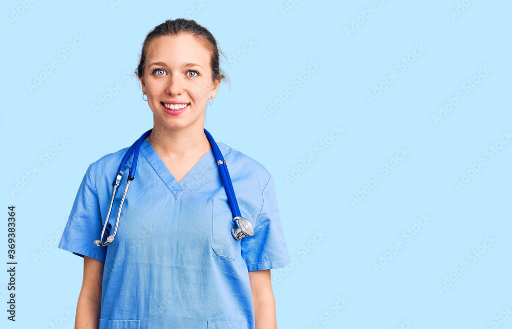 Young beautiful blonde woman wearing doctor uniform and stethoscope with a happy and cool smile on face. lucky person. Young beautiful blonde woman wearing doctor uniform and stethoscope with a happy and cool smile on face. lucky person.