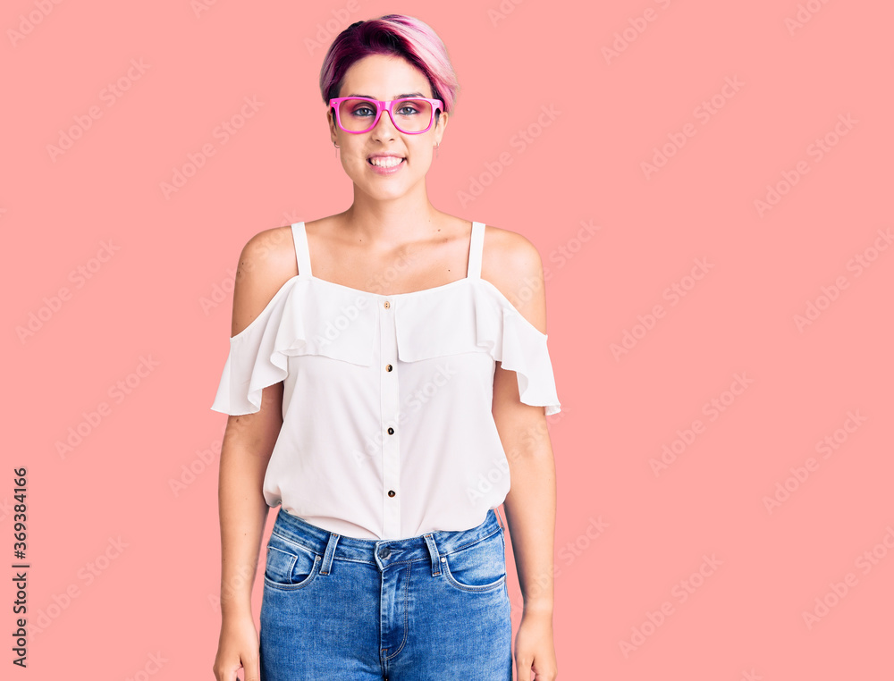 Young beautiful woman with pink hair wearing casual clothes and glasses with a happy and cool smile on face. lucky person. Young beautiful woman with pink hair wearing casual clothes and glasses with a happy and cool smile on face. lucky person.
