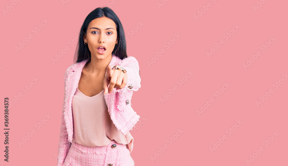 Young beautiful latin girl wearing business clothes pointing displeased and frustrated to the camera, angry and furious with you Young beautiful latin girl wearing business clothes pointing displeased and frustrated to the camera, angry and furious with you