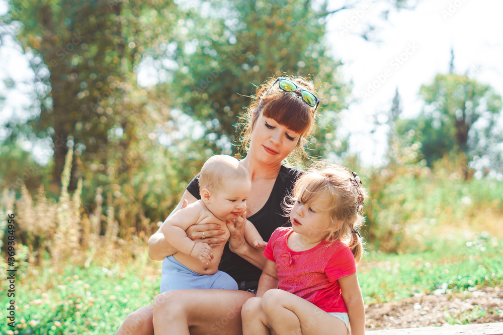 mother with children playing on a bench mother with children playing on a bench