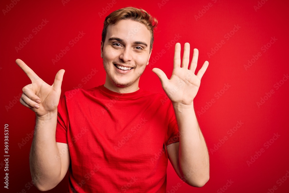 Young handsome redhead man wearing casual t-shirt over isolated red background showing and pointing up with fingers number seven while smiling confident and happy. Young handsome redhead man wearing casual t-shirt over isolated red background showing and pointing up with fingers number seven while smiling confident and happy.