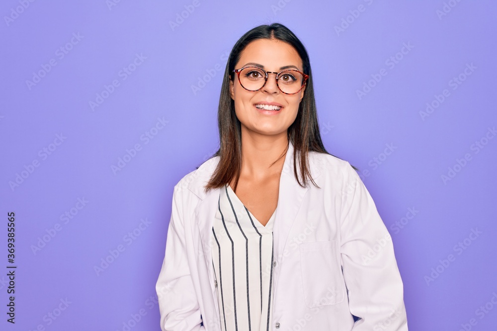 Young beautiful brunette psychologist woman wearing coat and glasses over purple background with a happy and cool smile on face. Lucky person.