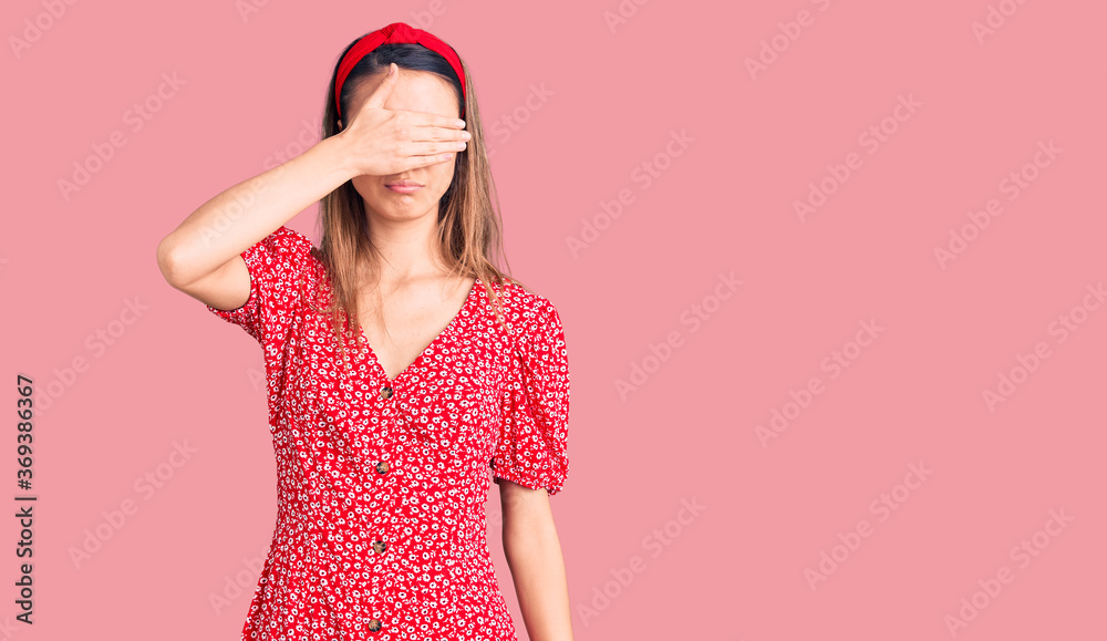 Young beautiful girl wearing dress and diadem covering eyes with hand, looking serious and sad. sightless, hiding and rejection concept Young beautiful girl wearing dress and diadem covering eyes with hand, looking serious and sad. sightless, hiding and rejection concept