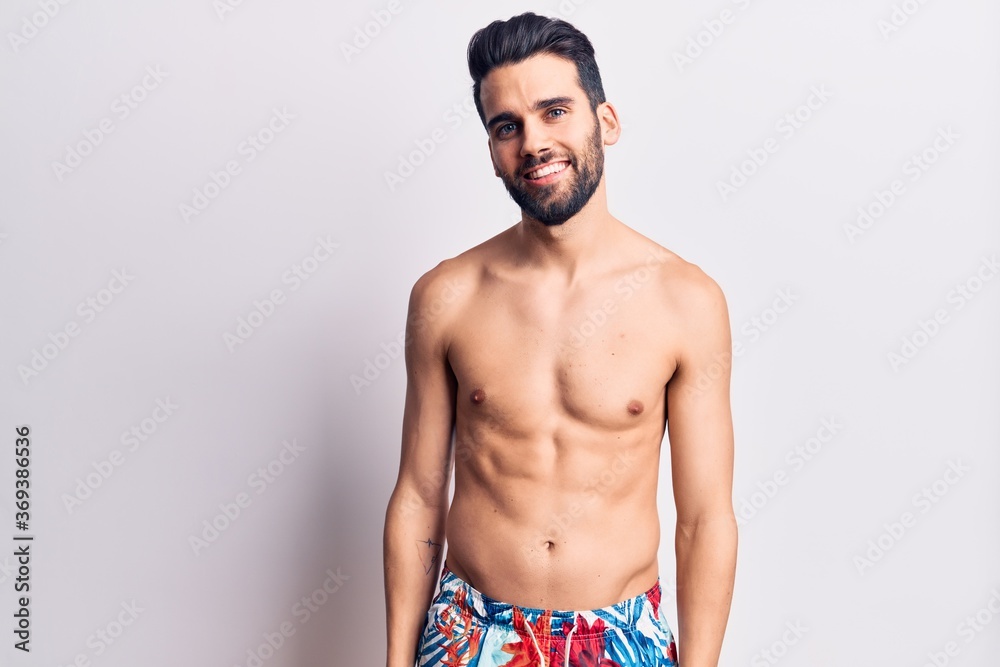 Young handsome man with beard shirtless wearing swimwear with a happy and cool smile on face. lucky person.