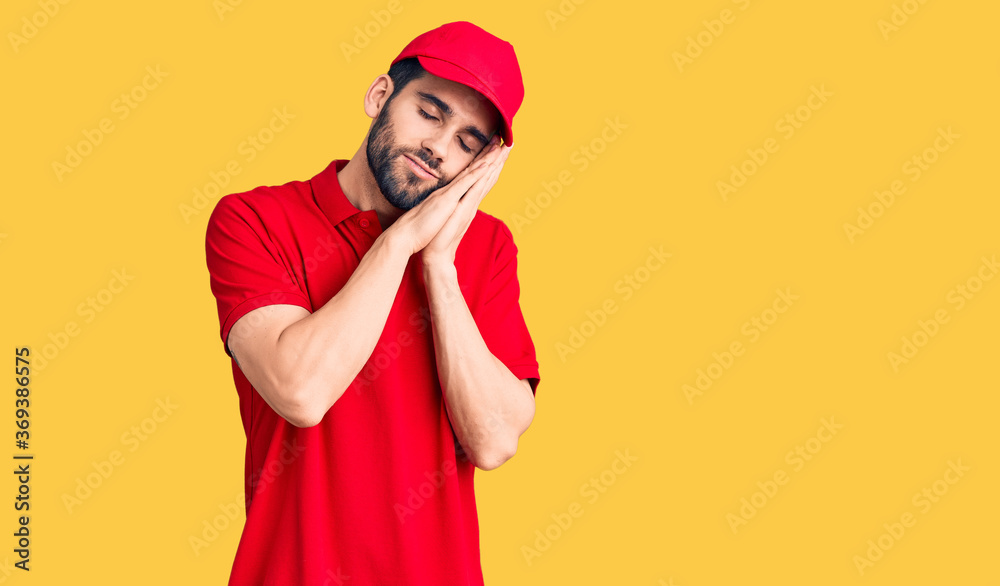 Young handsome man with beard wearing delivery uniform sleeping tired dreaming and posing with hands together while smiling with closed eyes. Young handsome man with beard wearing delivery uniform sleeping tired dreaming and posing with hands together while smiling with closed eyes.