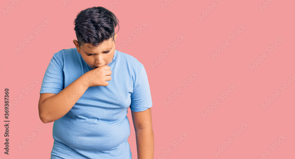 Little boy kid wearing sports workout clothes feeling unwell and coughing as symptom for cold or bronchitis. health care concept. Little boy kid wearing sports workout clothes feeling unwell and coughing as symptom for cold or bronchitis. health care concept.