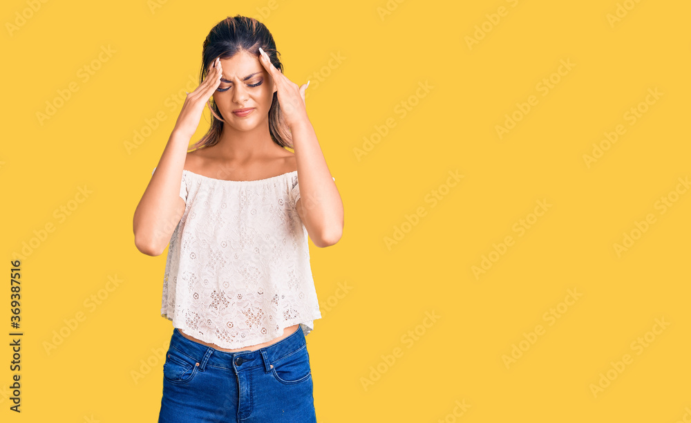 Young beautiful woman wearing casual clothes suffering from headache desperate and stressed because pain and migraine. hands on head. Young beautiful woman wearing casual clothes suffering from headache desperate and stressed because pain and migraine. hands on head.