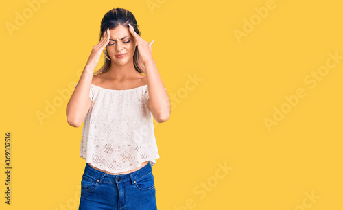 Young beautiful woman wearing casual clothes suffering from headache desperate and stressed because pain and migraine. hands on head.