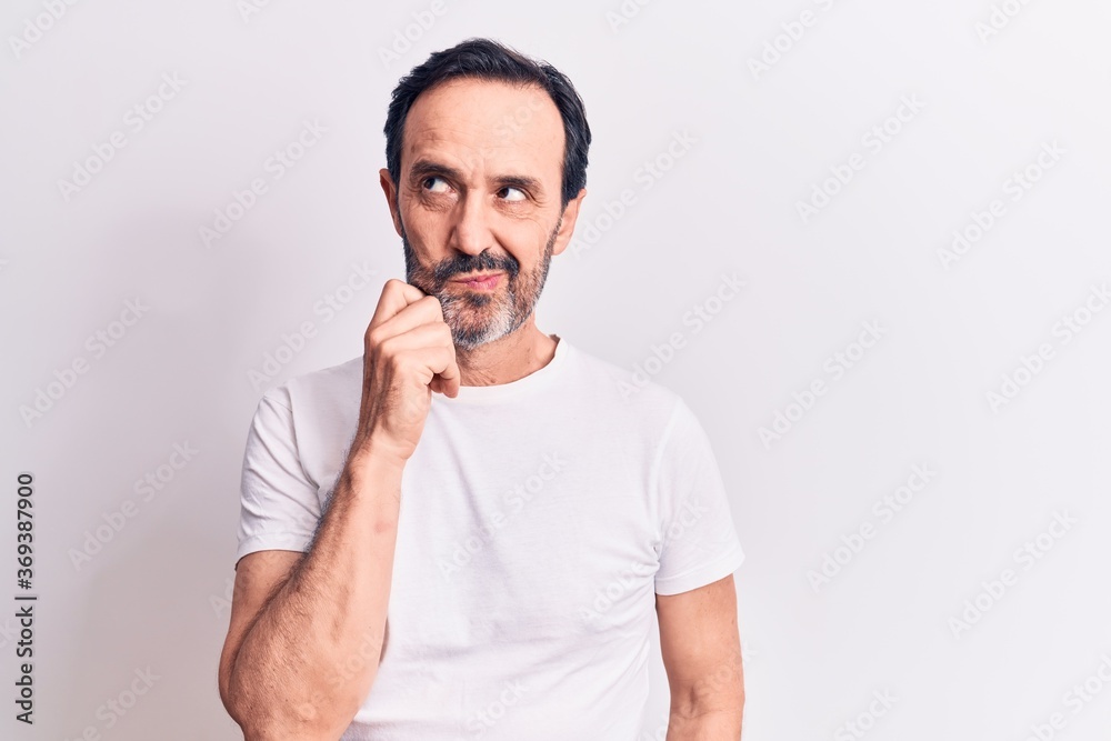 Middle age handsome man wearing casual t-shirt standing over isolated white background thinking concentrated about doubt with finger on chin and looking up wondering Middle age handsome man wearing casual t-shirt standing over isolated white background thinking concentrated about doubt with finger on chin and looking up wondering