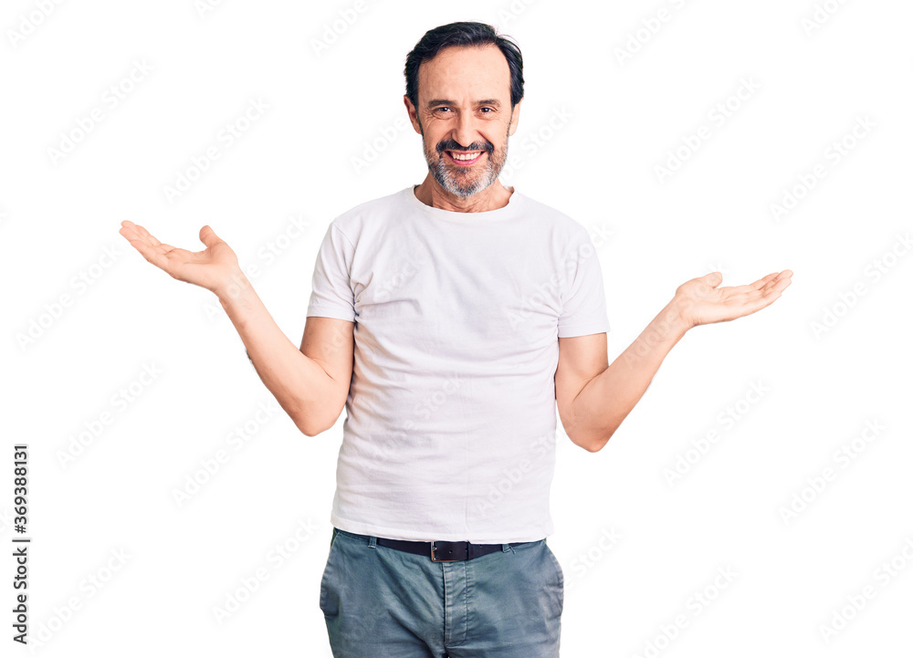 Middle age handsome man wearing casual t-shirt smiling showing both hands open palms, presenting and advertising comparison and balance Middle age handsome man wearing casual t-shirt smiling showing both hands open palms, presenting and advertising comparison and balance
