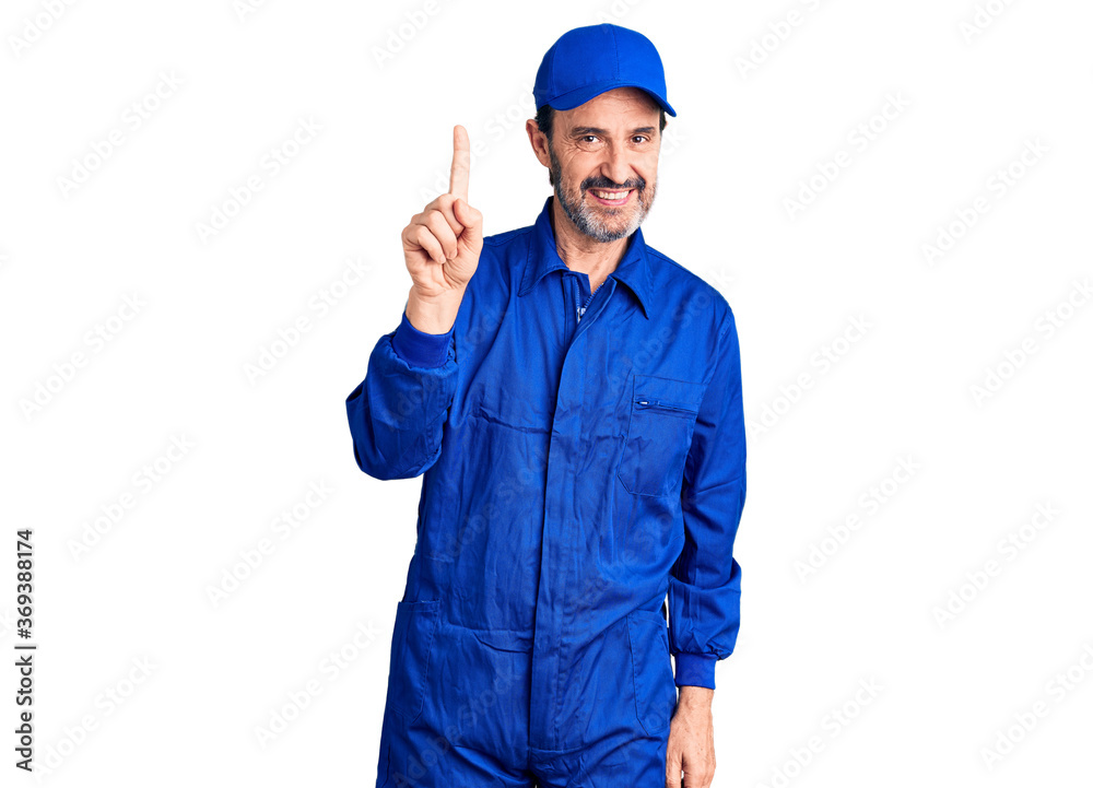 Middle age handsome man wearing mechanic uniform pointing finger up with successful idea. exited and happy. number one.