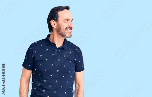 Wallpaper Mural Middle age handsome man wearing casual polo looking away to side with smile on face, natural expression. laughing confident. Torontodigital.ca