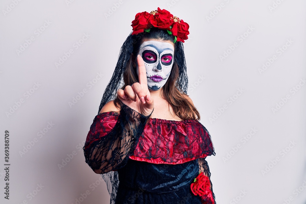 Young woman wearing day of the dead costume over white pointing with finger up and angry expression, showing no gesture Young woman wearing day of the dead costume over white pointing with finger up and angry expression, showing no gesture