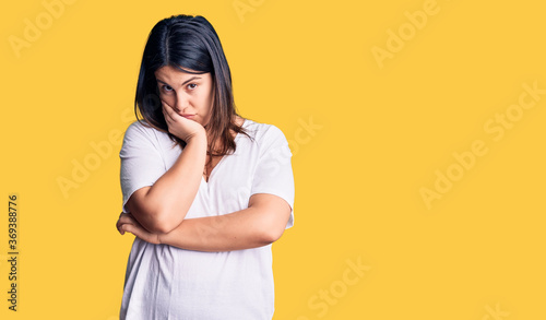 Young beautiful brunette woman wearing casual t-shirt thinking looking tired and bored with depression problems with crossed arms.