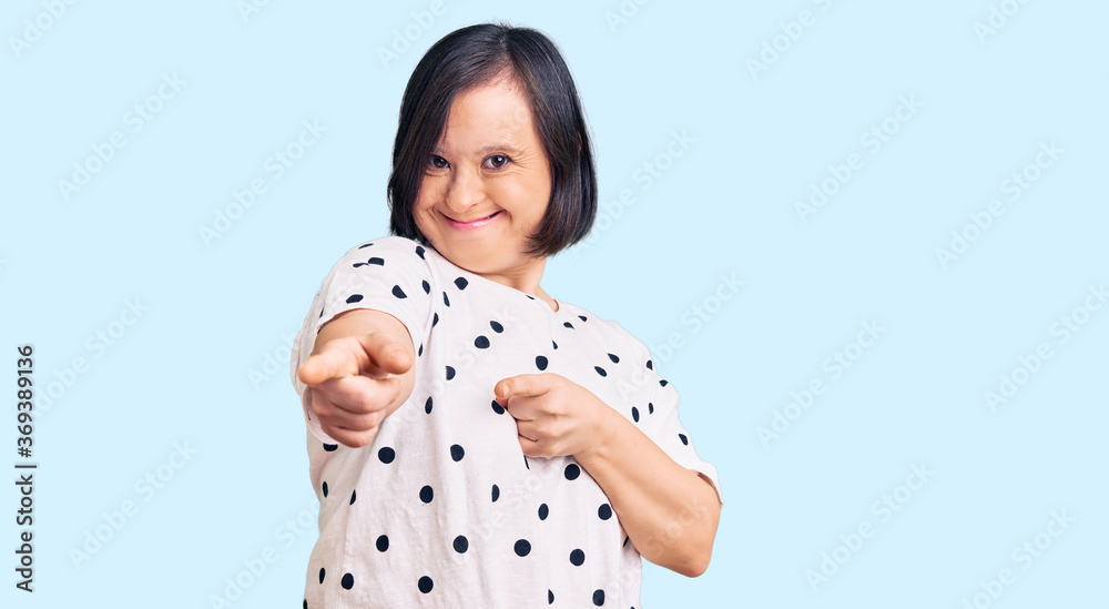 Brunette woman with down syndrome wearing casual clothes pointing fingers to camera with happy and funny face. good energy and vibes. Brunette woman with down syndrome wearing casual clothes pointing fingers to camera with happy and funny face. good energy and vibes.