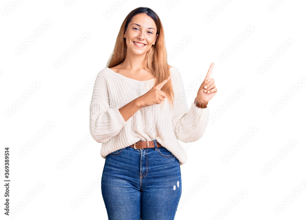 Beautiful young woman wearing casual clothes smiling and looking at the camera pointing with two hands and fingers to the side. Beautiful young woman wearing casual clothes smiling and looking at the camera pointing with two hands and fingers to the side.