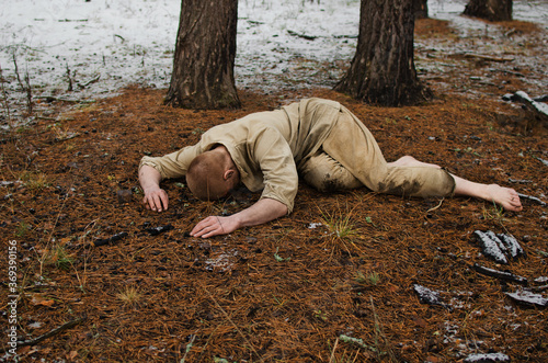 soldier lying in a winter forest world war II