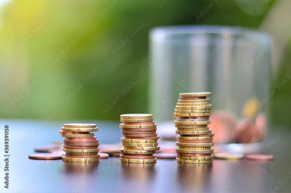 A pile of coins resting on a wooden floor A pile of coins resting on a wooden floor