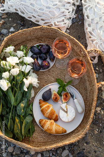 Summertime concept. Beach picnic with wine and croissants