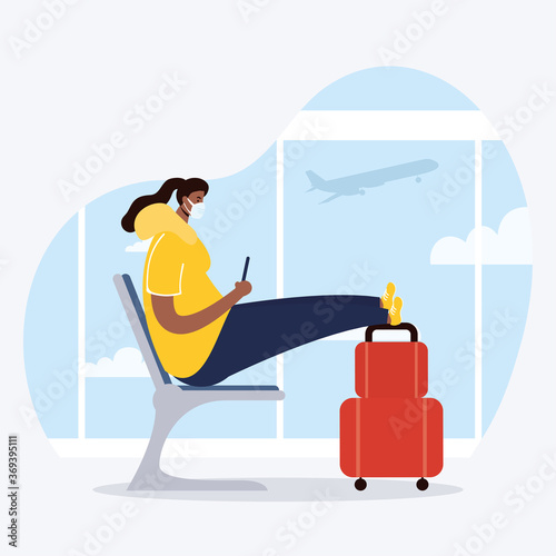 afro young woman wearing medical mask with suitcase in waitingroom