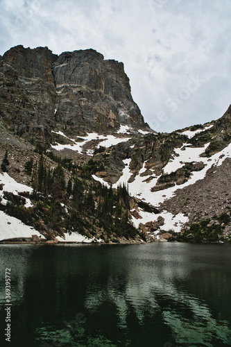 Emerald lake in rocky mountain national park on a sunny day. Colorado summer in mountains still show snow on the mountain tops over a long hike