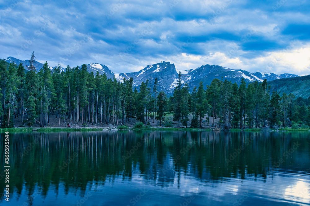 Sprague lake at sunset. Cold scene in rocky mountain national park colorado. Snow capped peaks visible and reflecting off lake surface. Beautiful and peaceful scene in Colorado mountains