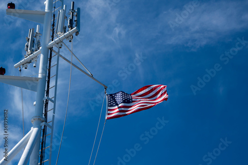 United States of America Flag Blowing in the Wind on the the deck of a large ship at sea photo