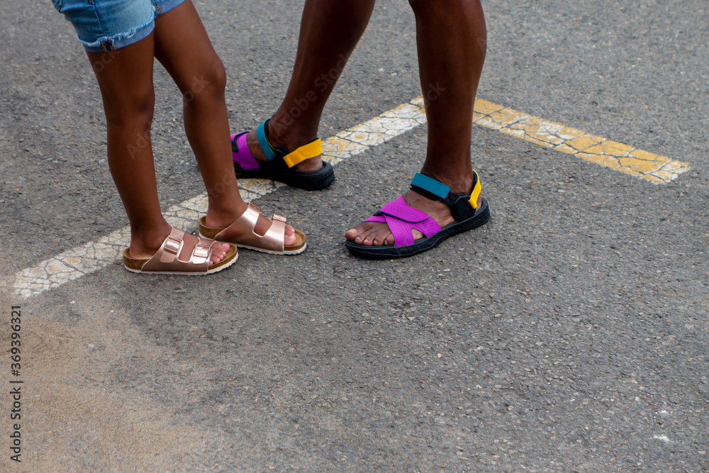 young african american girl on black top steet with her father in shorts and sandals