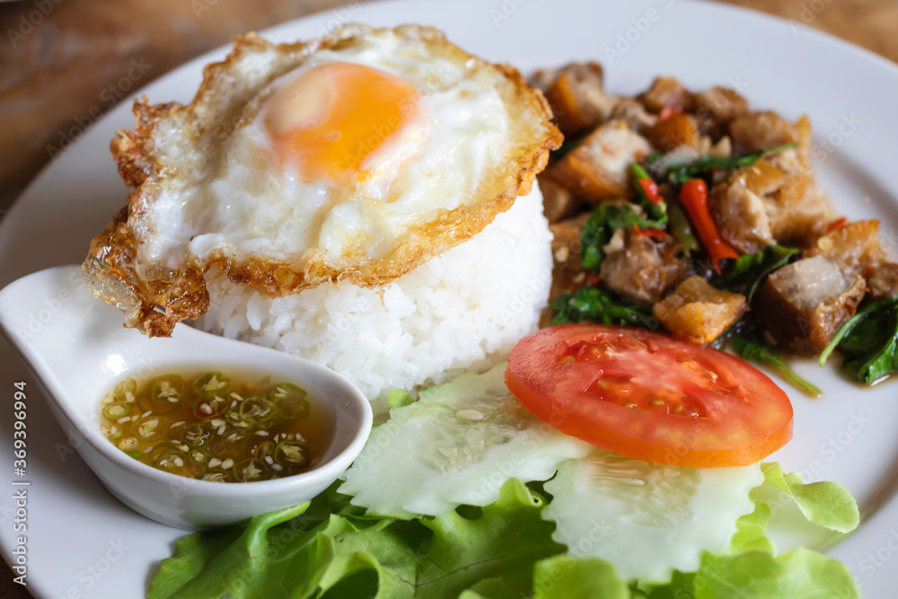 Rice topped with stir-fried pork and basil with On a plate and fried egg