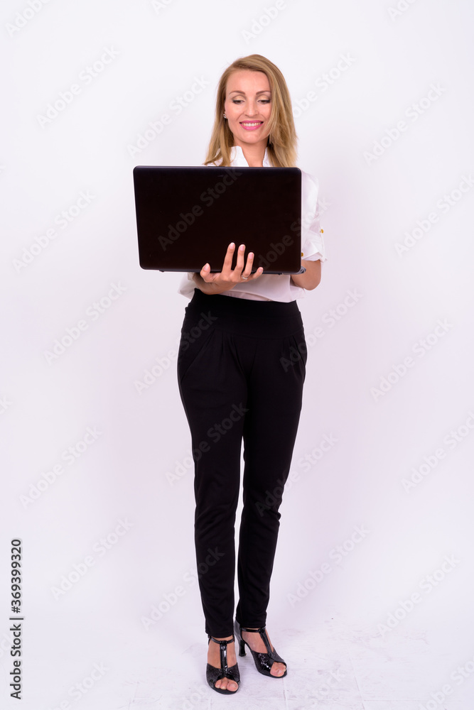 Naklejka premium Portrait of happy beautiful businesswoman with blond hair using laptop