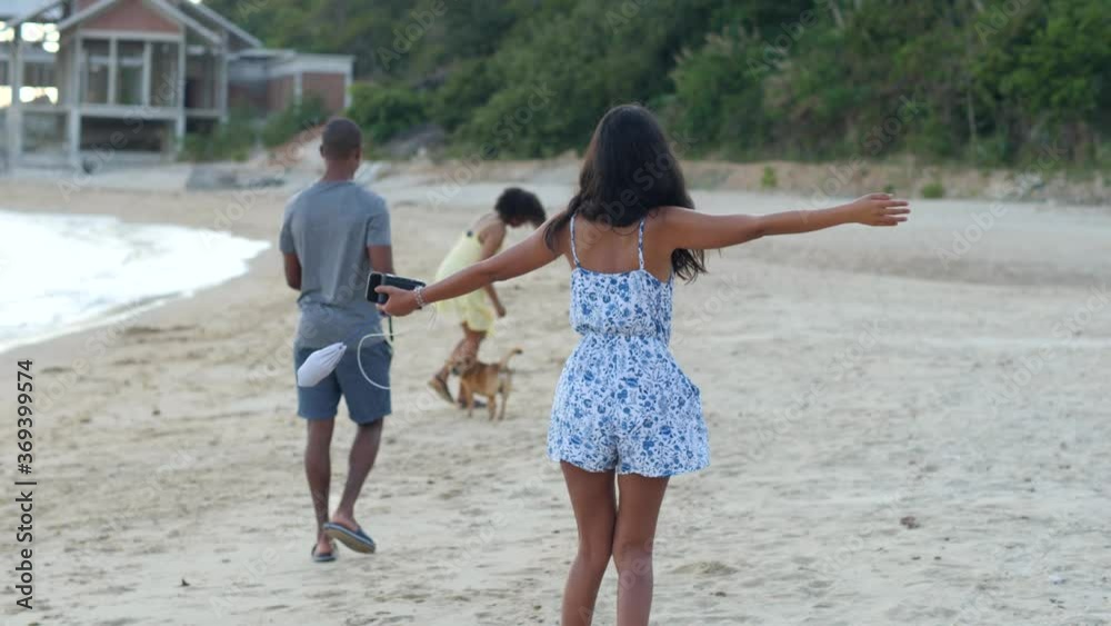 Carefree Asian girl in summer dress raising hands and turning around at the beach. Carefree Asian girl in summer dress raising hands and turning around at the beach.