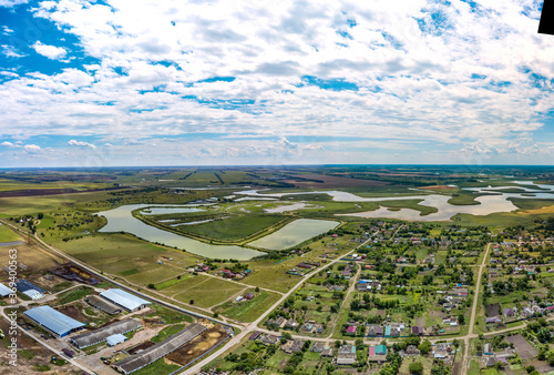 the floodplain of the Beysug flat river with many islands between the villages of Pereyaslavskaya and Bryukhovetskaya (Krasnodar Territory, southern Russia). Aerial drone panorama on hot summer cloudy photo