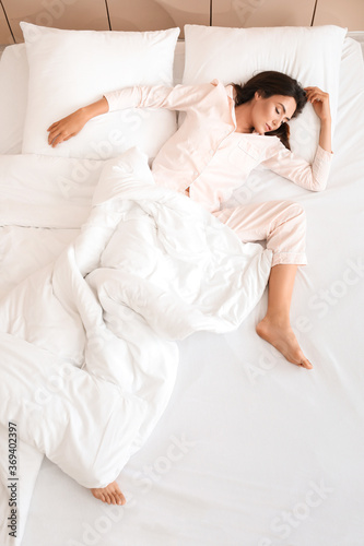 Young woman sleeping in bed, top view © Pixel-Shot