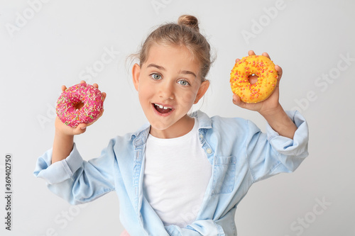 Funny little girl with donu...