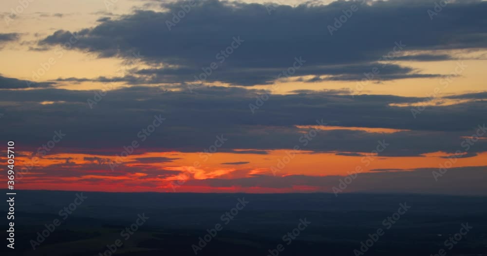 Zoomed out during sunset on a mountainous hilly landscape with orange sunset and shadows over the city and countryside. Zoomed out during sunset on a mountainous hilly landscape with orange sunset and shadows over the city and countryside.