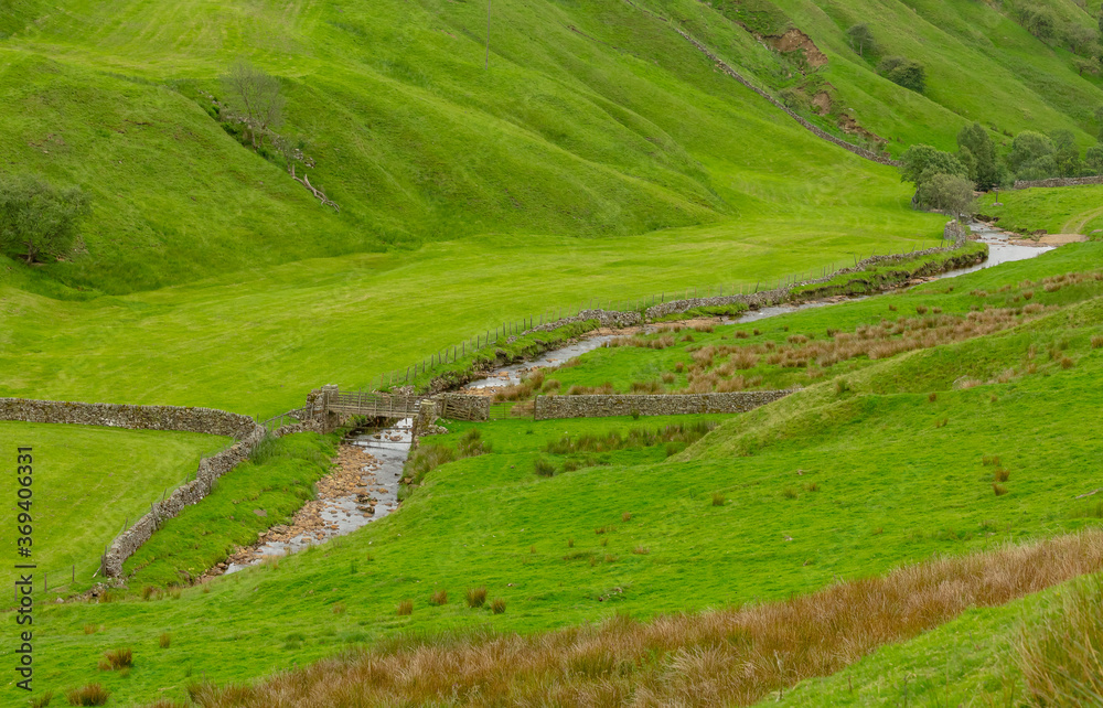 Stonesdale beck in summer, which meanders through a deep sided valley near Keld in Swaledale, North Yorkshire. Horizontal. Space for copy. Stonesdale beck in summer, which meanders through a deep sided valley near Keld in Swaledale, North Yorkshire. Horizontal. Space for copy.