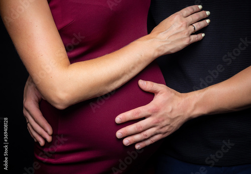 Portrait of a young couple waiting for a baby. Taken in a photo Studio on a black background.