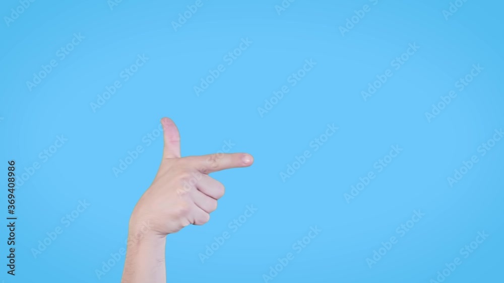 Close-up of man's hand pointing to the right side. The male enters his hand into the frame and points to the right with index finger.Studio shot on blue background.Advertisement,direction concept. Close-up of man's hand pointing to the right side. The male enters his hand into the frame and points to the right with index finger.Studio shot on blue background.Advertisement,direction concept.