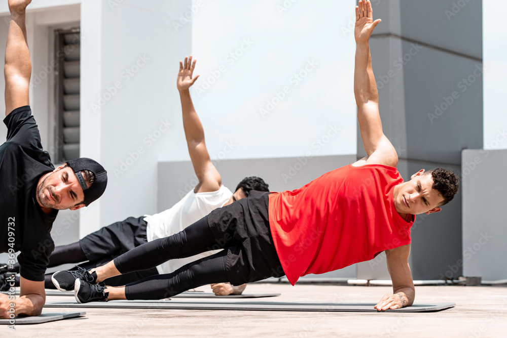 © Atstock Productions - Handsome athletic men doing side plank bodyweight workout training outdoors on building rooftop in sunlight © Atstock Productions - Handsome athletic men doing side plank bodyweight workout training outdoors on building rooftop in sunlight