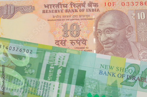 Wallpaper Mural A macro image of a orange ten rupee bill from India paired up with a green and white fifty shekel bank note from Israel.  Shot close up in macro. Torontodigital.ca