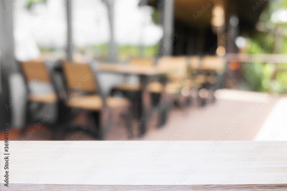 Empty wooden desk space and blurry background of coffee shop or Restaurant for product display montage. Empty wooden desk space and blurry background of coffee shop or Restaurant for product display montage.