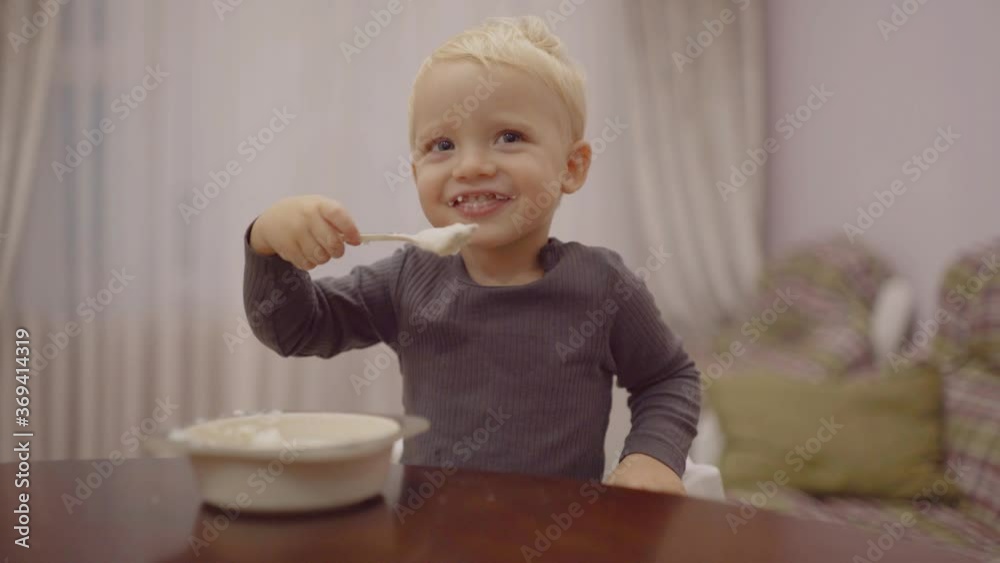 Cute smile kid having breakfast in the kitchen. Food for Child. Kids are eating milk snack. Cute smile kid having breakfast in the kitchen. Food for Child. Kids are eating milk snack.