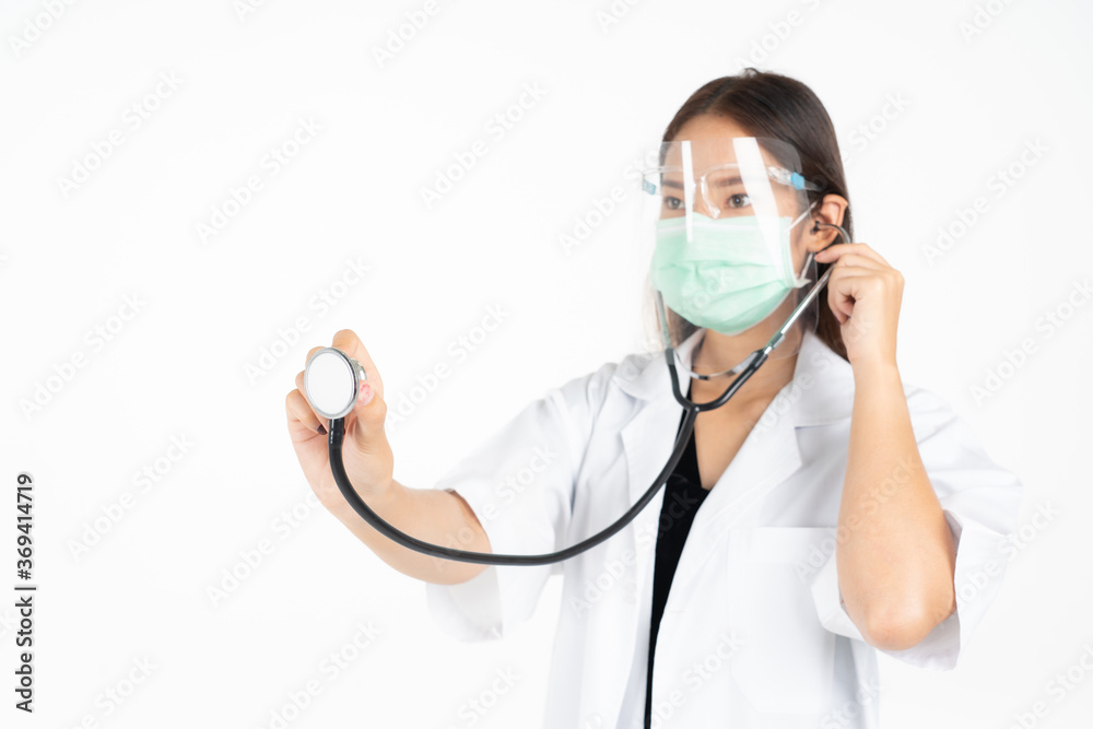 selective focus of asian female doctor with face shield and face mask in uniform using stethoscope, isolated on white.