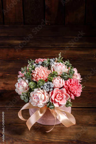 Bouquet of beautiful bright rose flowers in a gift cylindrical cardboard box © chernikovatv